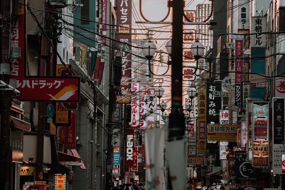 カラフルなネオンサインと都市の建築が溢れる賑やかな東京の通り、街の活気ある本質を捉えています。