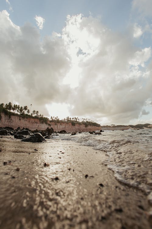 Sandy beach washed by ocean in sunlight