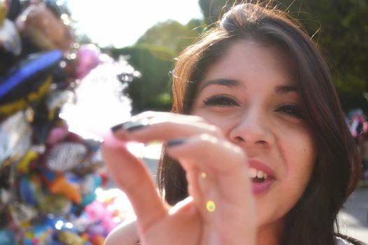 A happy woman enjoying a vibrant outdoor festival with colorful balloons in the background.