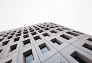 White Concrete Building with Glass Windows Under White Sky
