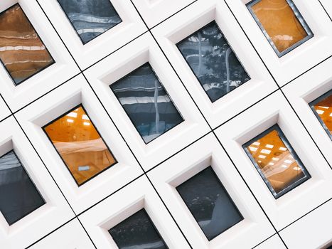 Contemporary building facade with geometric windows reflecting urban surroundings in Nanjing, China.