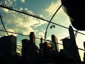 现代建筑与生动的日落天空相映衬，勾勒出戏剧性的城市景观轮廓