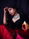 Woman in Black Sleeveless Dress Sitting on Red Textile