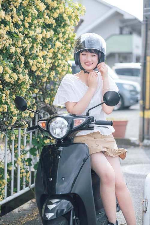 Photo of a Woman Smiling while Wearing Her Helmet