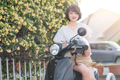 Free Photo of a Beautiful Woman Sitting on a Black Scooter Stock Photo