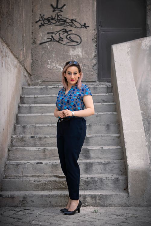 Free Middle Eastern woman stands stylishly on an urban staircase in Tehran. Stock Photo