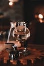 Water in glass sphere of siphon coffee maker with heater placed on table in cafe