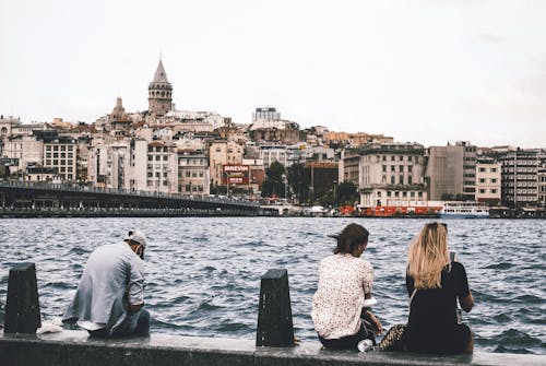 People Sitting on the Seawall of Bosporus Strait in Istanbul