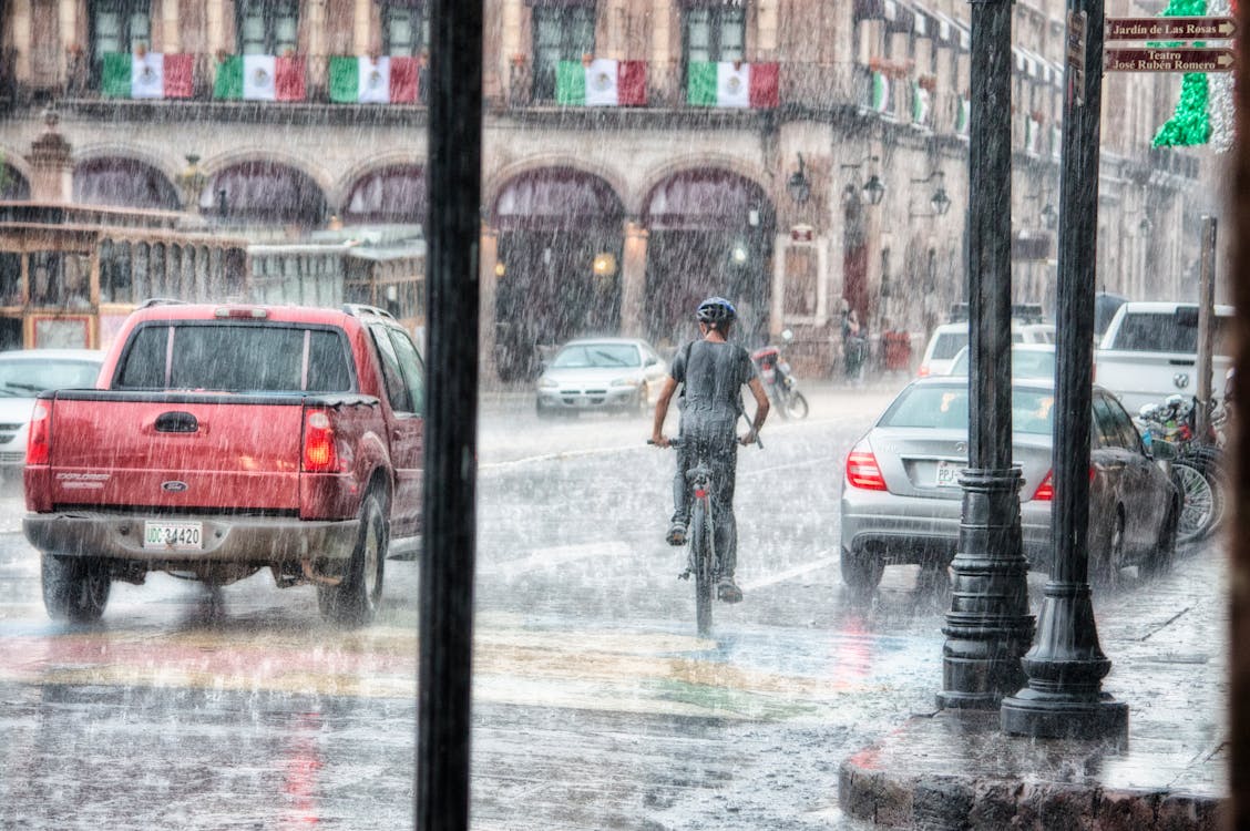 Person Riding a Bicycle during Rainy Day