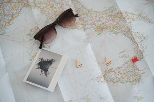 Sunglasses and travel items placed on a world map, perfect for journey planning and exploration.