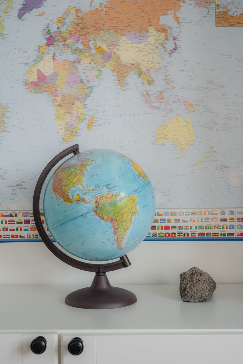 Desktop globe positioned against a colorful world map background