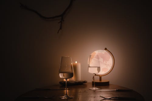 Wine Glasses and an Illuminated Globe on a Wooden Table