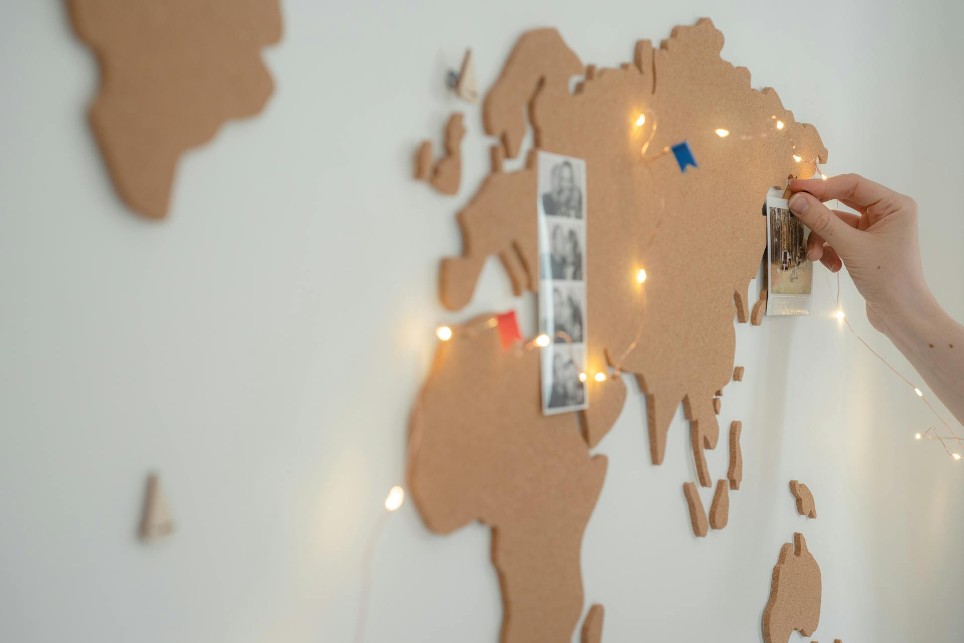 A Person Pinning Photos on the Map