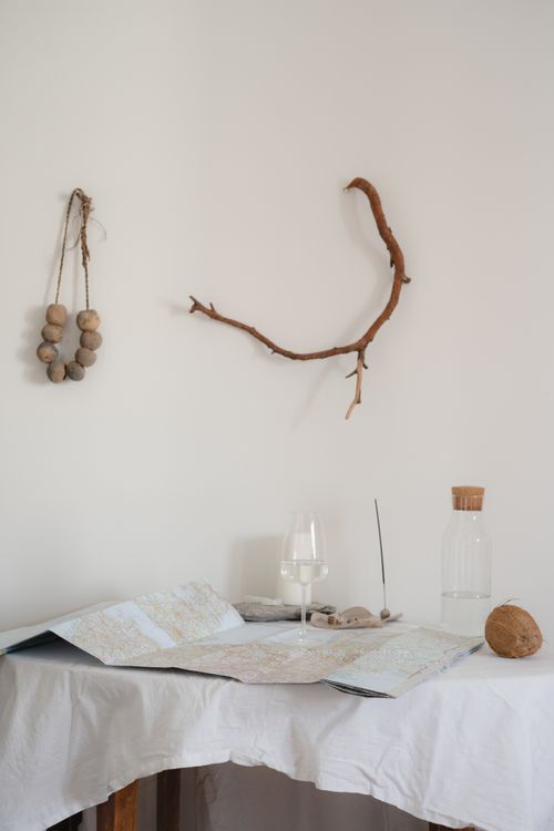 Free A minimalist still life featuring a map, glass of water, and decorative elements on a table. Stock Photo