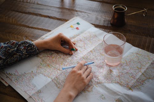 Hands of Woman Placing Flag on Map of Iberian Peninsula