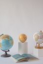 Globes on the White Table Near a Book