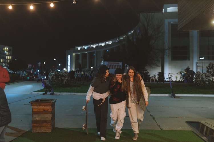 Women With Skateboards Walking On The Street