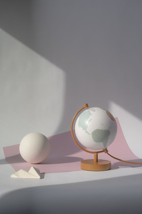 A Globe and a White Sphere on the Paper