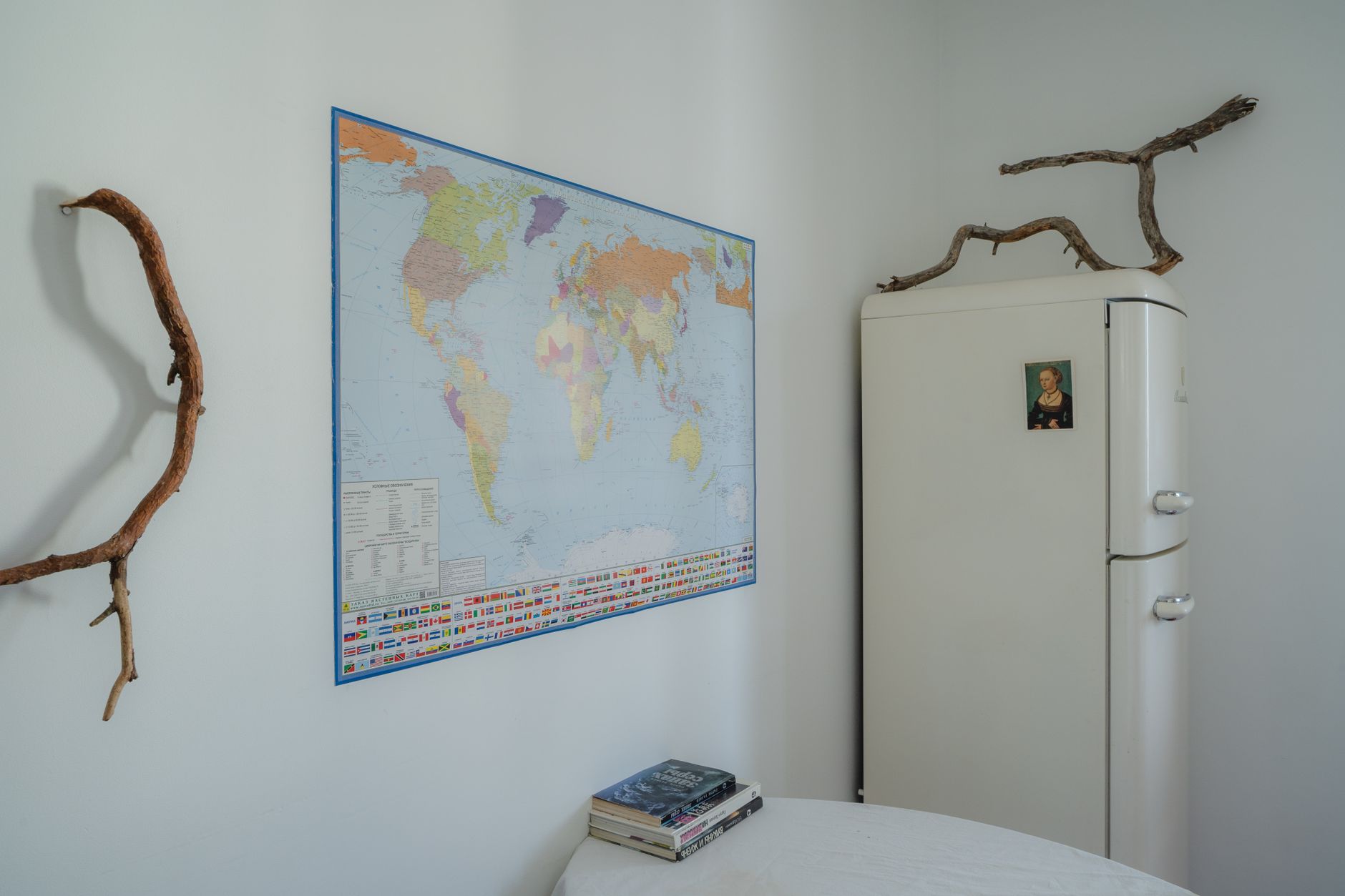 A minimalist room featuring a world map and vintage refrigerator, perfect for travel enthusiasts.