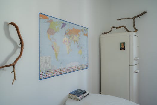 A minimalist room featuring a world map and vintage refrigerator, perfect for travel enthusiasts.