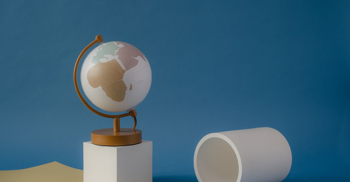 Globe minimaliste sur un support géométrique avec un fond abstrait.