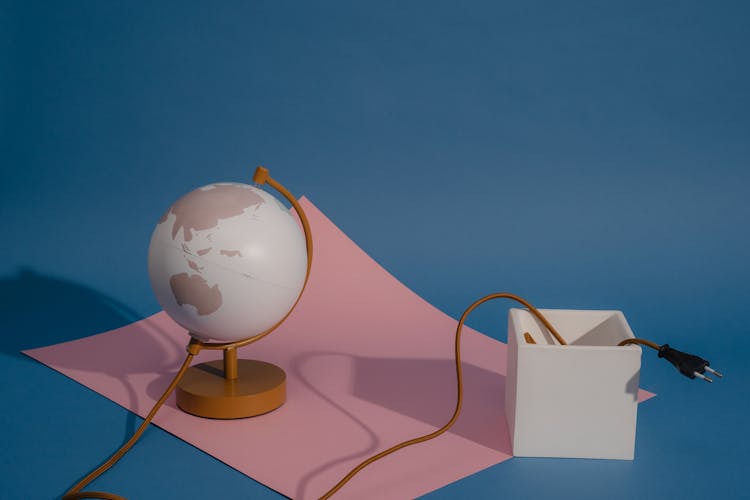 White And Blue Globe On Brown Wooden Table