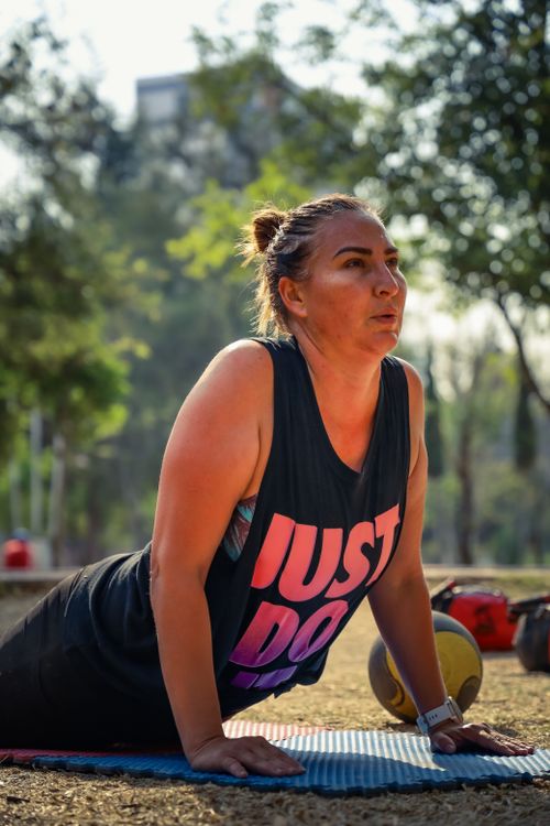 Free Woman practicing yoga on mat in sunny Puebla park, promoting fitness and healthy lifestyle. Stock Photo