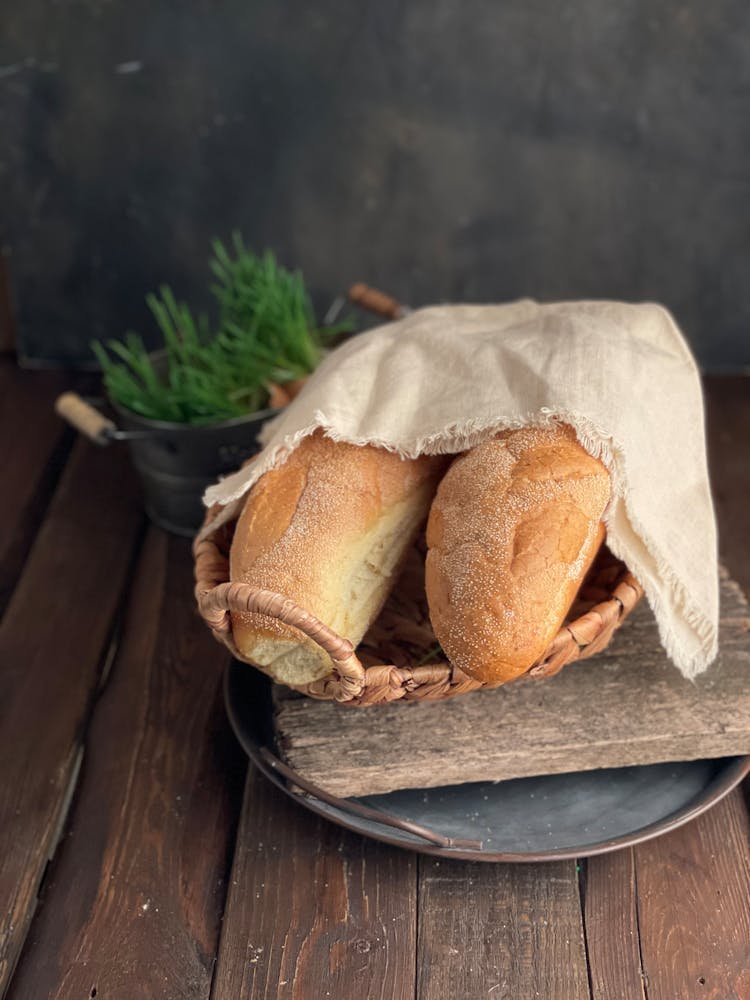 Baguette In A Wicker Basket With A Textile On Top