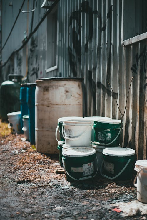 Free Barrels and buckets near shabby house Stock Photo