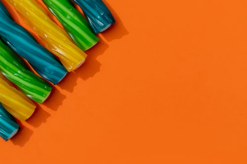 Colorful Candy Sticks on an Orange Surface