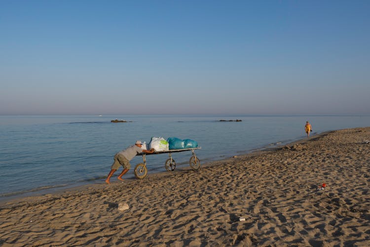 Man Pushing Cart On Beach