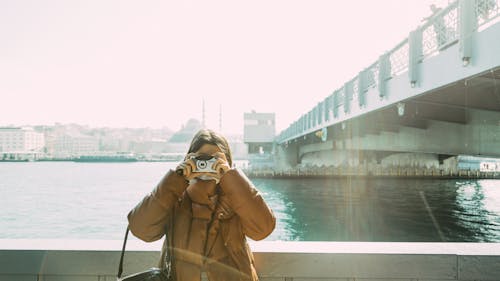 Woman in Brown Coat Taking Picture