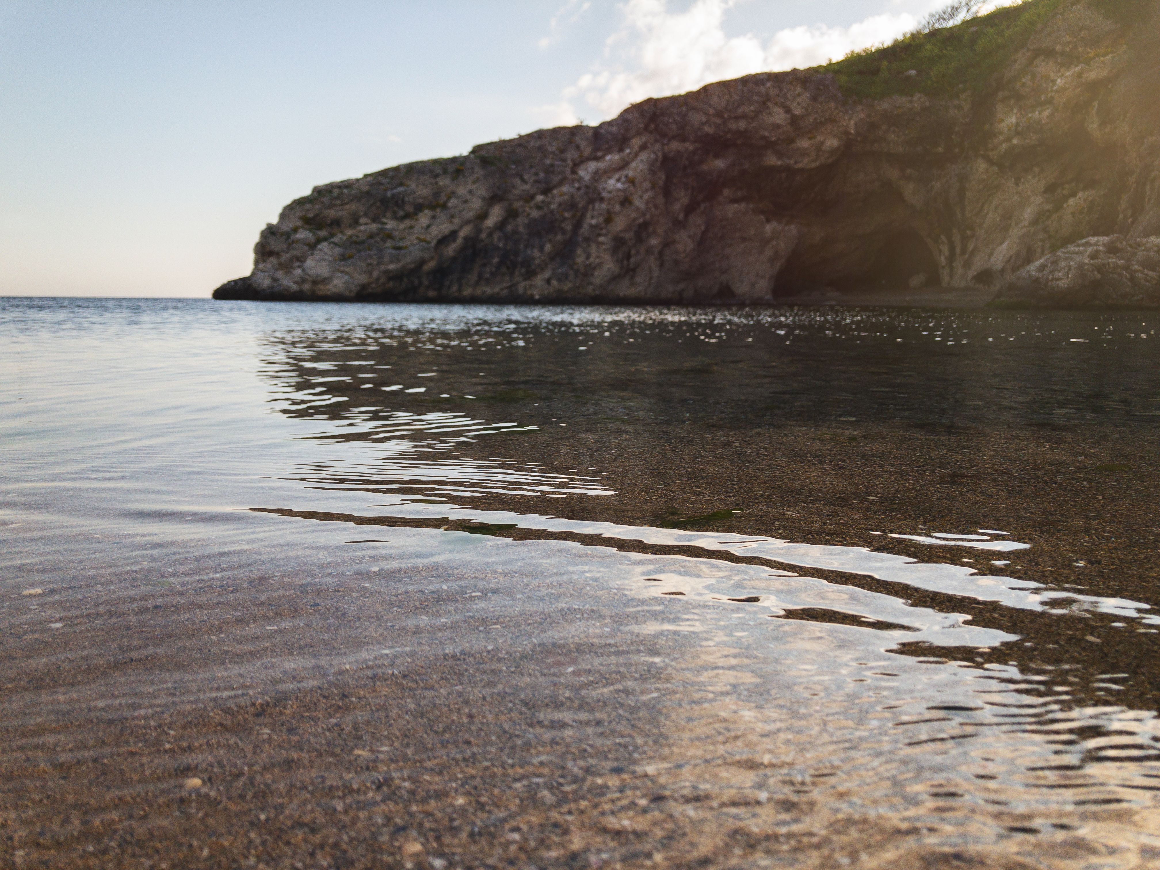 Peaceful view of a calm sea meeting a rugged cliff at Şile beach in Istanbul.