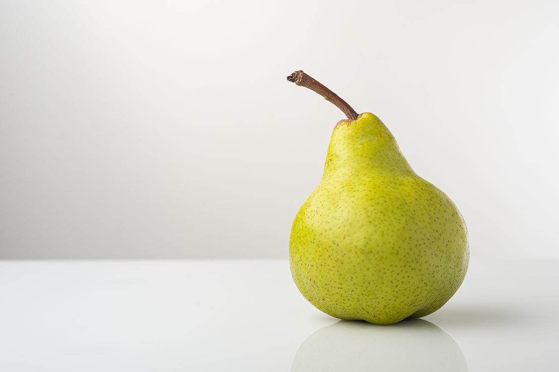 Close-Up Photo of a Pear on a White Surface · Free Stock Photo