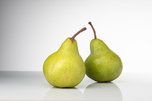 Free Two Fresh Green Pears on a White Surface Stock Photo