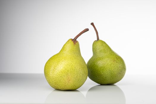 Bright and fresh green pears on a clean white background, symbolizing healthy eating and fresh produce.