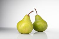 Fresh green pears on a white background — photo by Evgeniy Alekseyev on Pexels