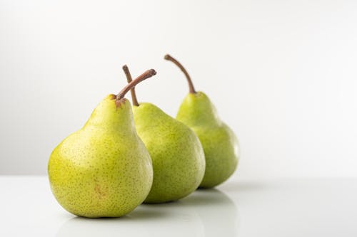 Free Close-Up Photograph of Three Pears on a White Surface Stock Photo