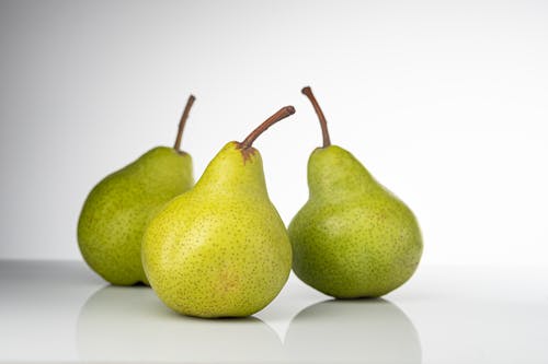 Free Three Fresh Pears with Brown Stems Stock Photo