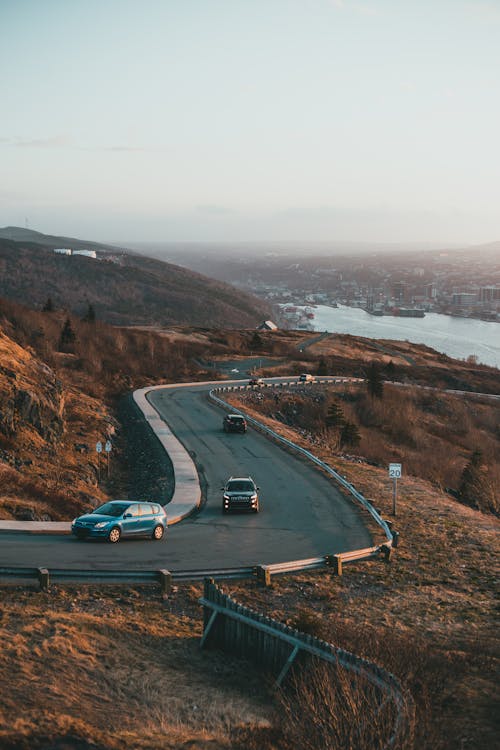 Cars driving on road against lake