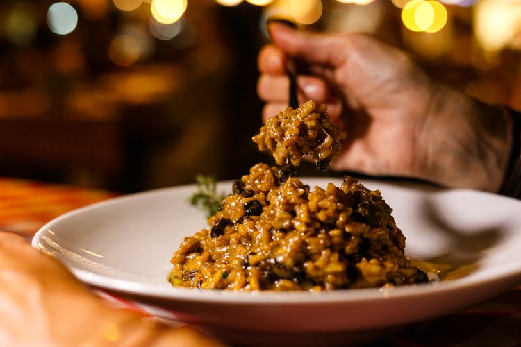 Close-up Of Person Eating Risotto