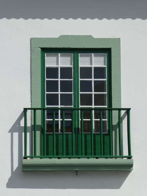 Free Classic green-framed balcony with glass doors on a white facade Stock Photo