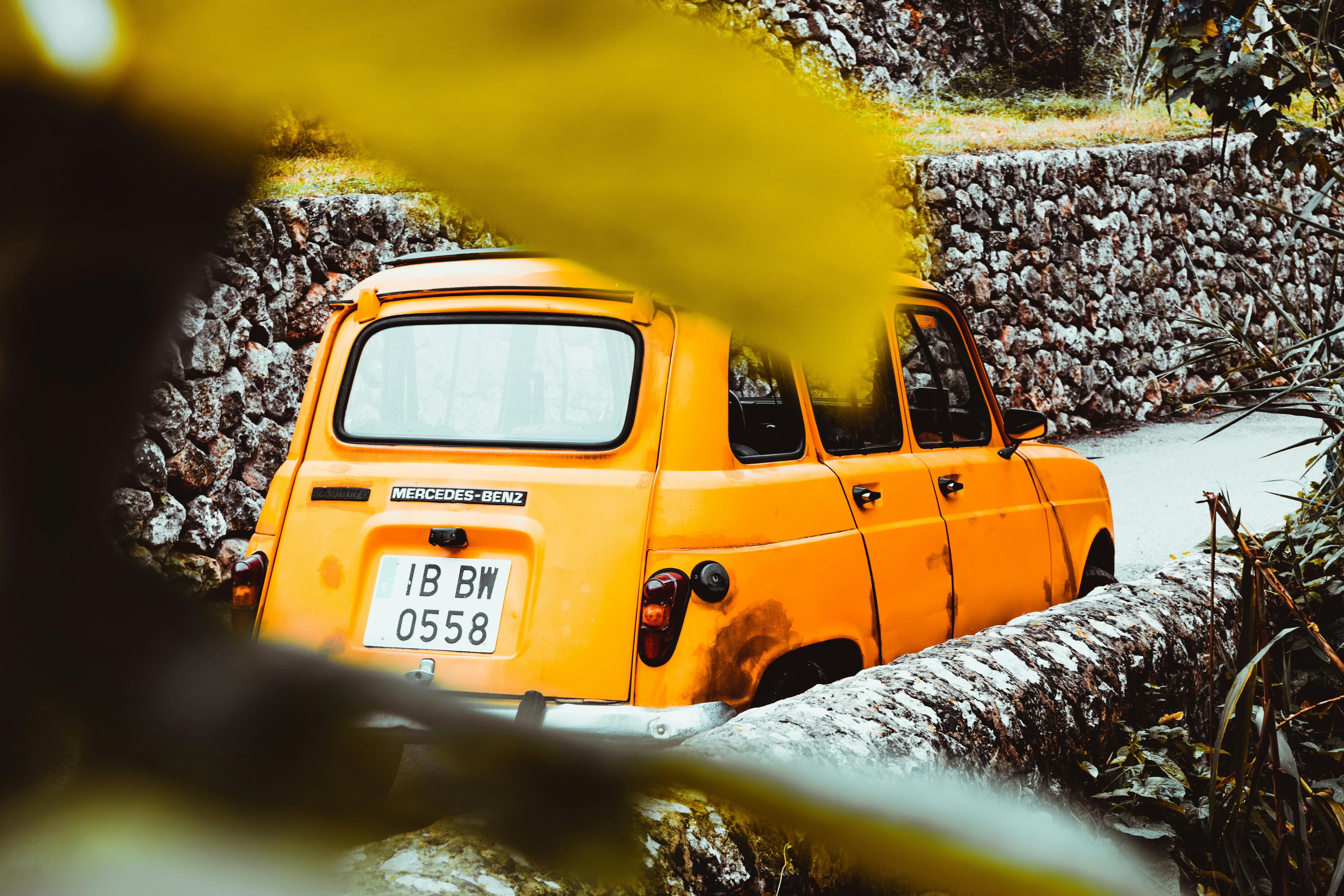 一辆经典的黄色梅赛德斯-奔驰汽车停在西班牙巴利尔斯的乡间小路上