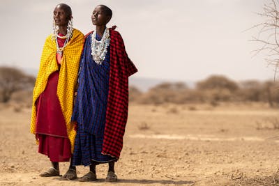 Samburu elder wearing colorful beads and traditional clothing in a vast landscape