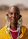 Woman in Yellow and Black Polka Dot Shirt Wearing Gold Beaded Necklace