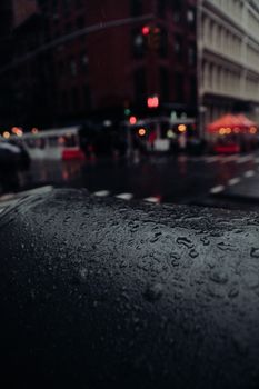 Dark wet surface against asphalt road on city street in rainy day in evening time