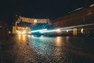 城市街道上，夜间行驶的汽车与节日灯光构成迷人景象