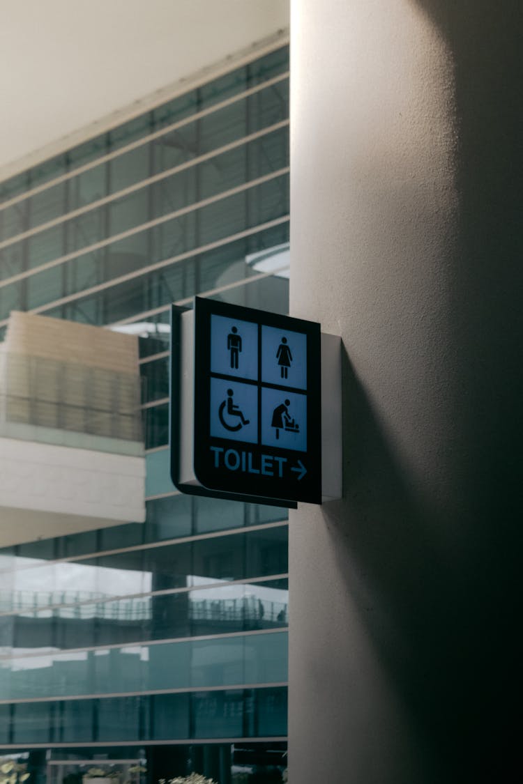 Signboard Of Public Toilet Placed On Wall