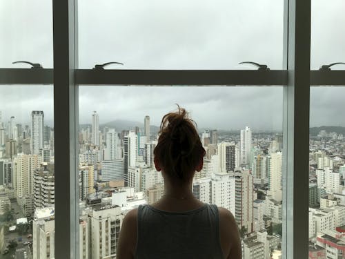 Femme Debout Près De La Fenêtre En Verre