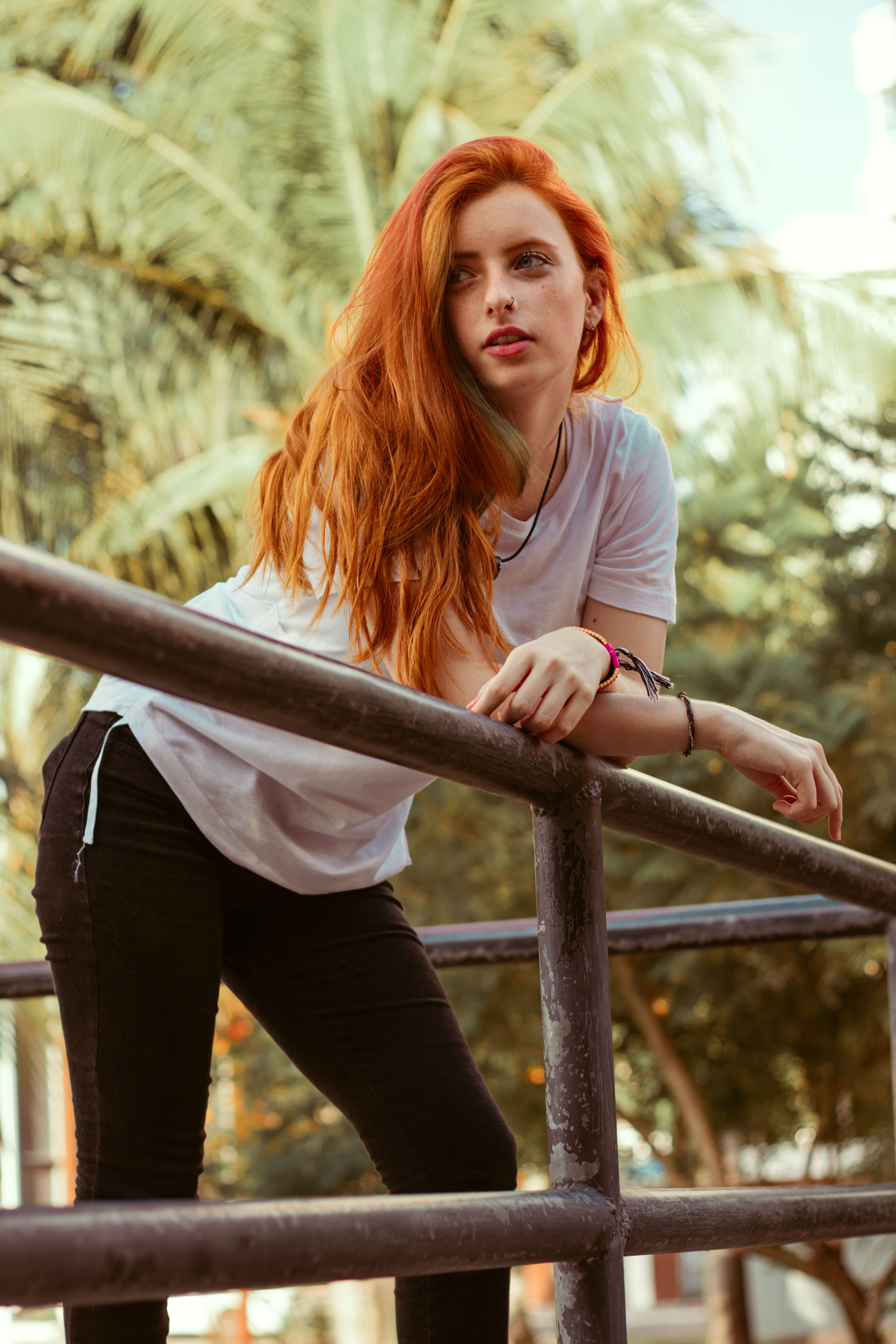 Woman with Red Hair Leaning on Railings while Looking at the Camera · Free  Stock Photo